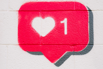 A social media like icon -a heart and a number 1 in a red speech bubble