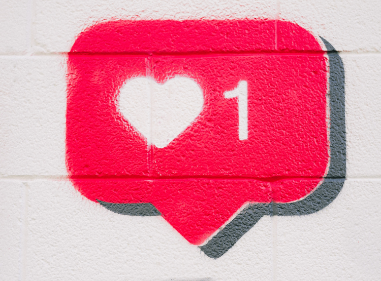 A social media like icon -a heart and a number 1 in a red speech bubble